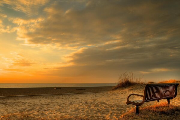 Banc sur la plage au coucher du soleil