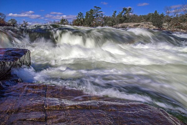 Un flot d eau qui fait rage et qui s effondre des rochers