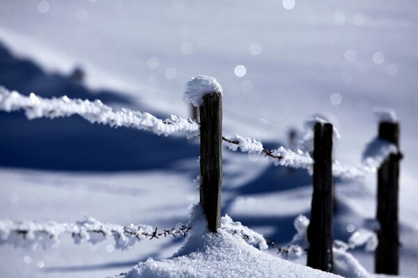 Ein Zaun, der mit Schnee bedeckt ist. Winter Natur