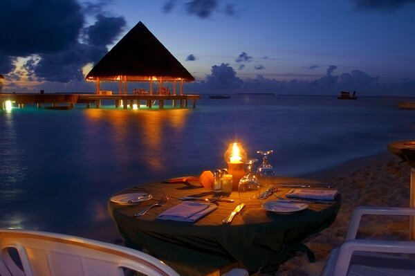 Dîner romantique sur la plage le soir sur le fond de l océan voir