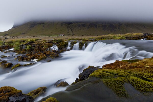 A swirling river under a cloud of fog in the hills