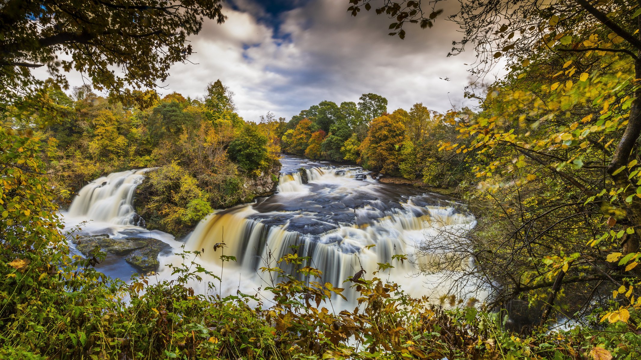 schottland clyde tal wald herbst wald fluss strömung wasserfall kaskade steine bäume zweige blätter