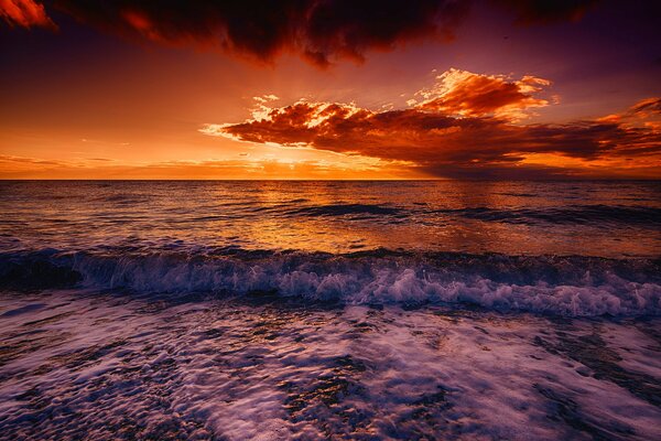 Surf sur fond de lueur dans la mer avec des nuages