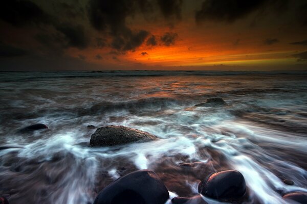 Acqua che lava le pietre al tramonto