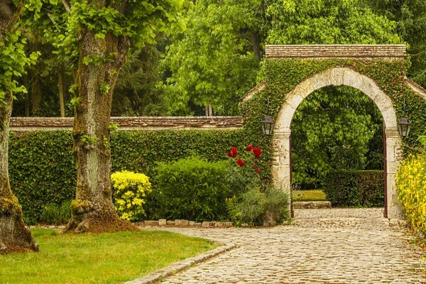 Arco de piedra en el verde en el parque