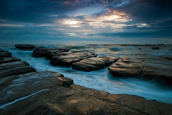 El cielo de la tarde en el fondo de las rocas de las piedras y el mar