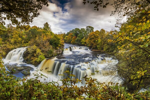 Ein Wasserfall in Schottland unter Bäumen