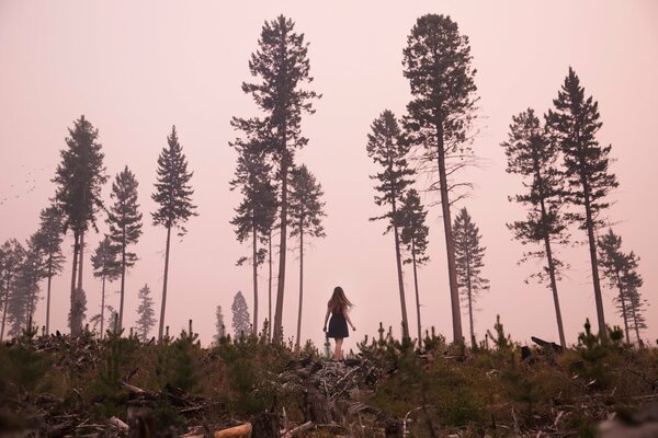 Ragazza in piedi in mezzo alla foresta