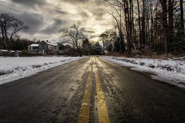 Winter road among woods and houses