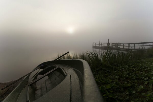 Morning with fog and a boat on the lake