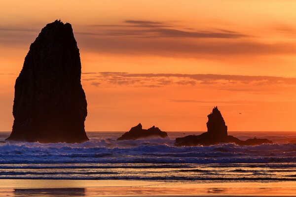 Orange Sonnenuntergang unter den Felsen
