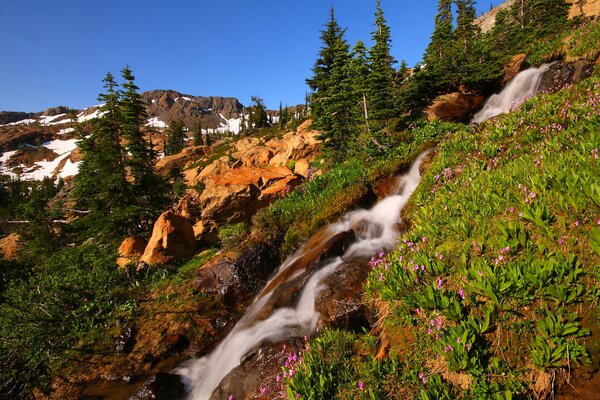 Neige sur les pentes des montagnes et cascade