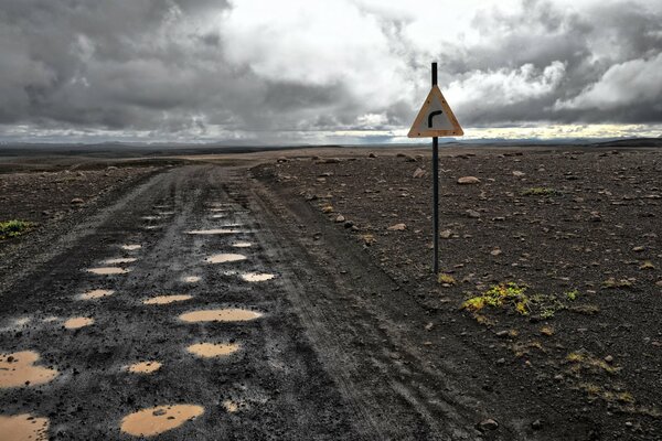 Camino de tierra y letrero en la carretera