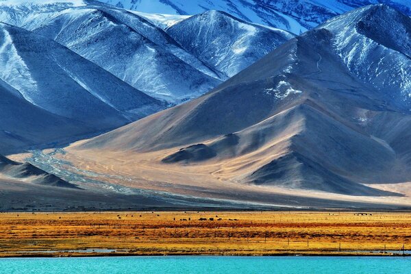 Majestuosas montañas en la nieve cerca del lago