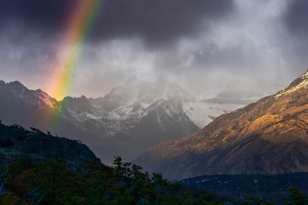 A bright rainbow in the cloudy mountains