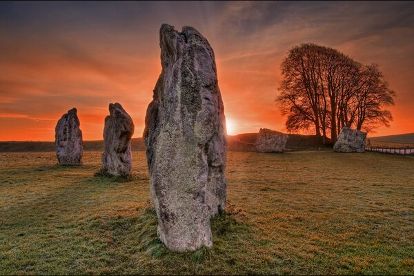 Sunset in the savannah with the image of a megalith in the rays