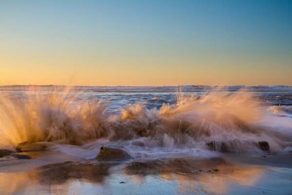 Salpicaduras de olas rompiendo en la orilla del mar
