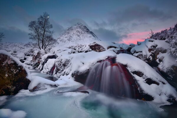 Río en las montañas en invierno por la noche