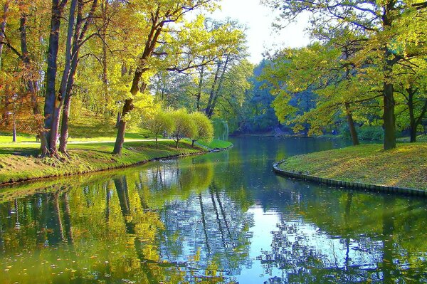 Herbstpark mit Fluss und Bäumen