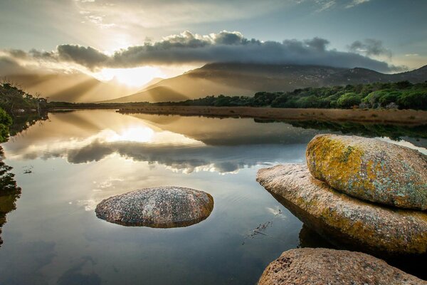 Reflection of the sun in the water of a mountain lake