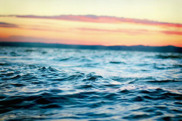 Mesmerizing blue waves against the sunset background