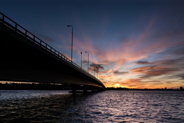 Sunset over the bridge in the sea