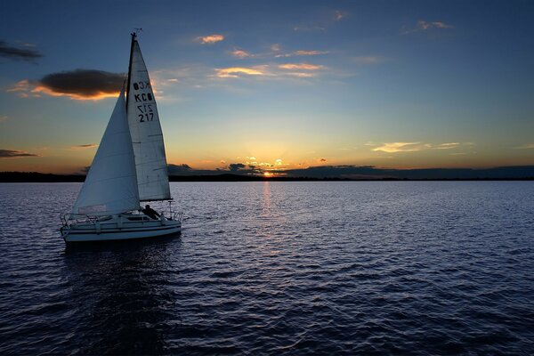 Un velero navega al atardecer