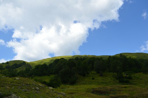 Wolken über dem grünen Alpendorf