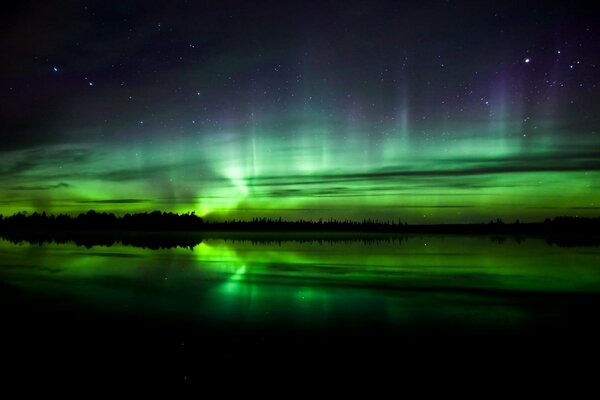 The Northern lights are reflected in the water