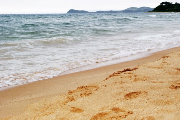 Vagues de la mer bleue sur le sable