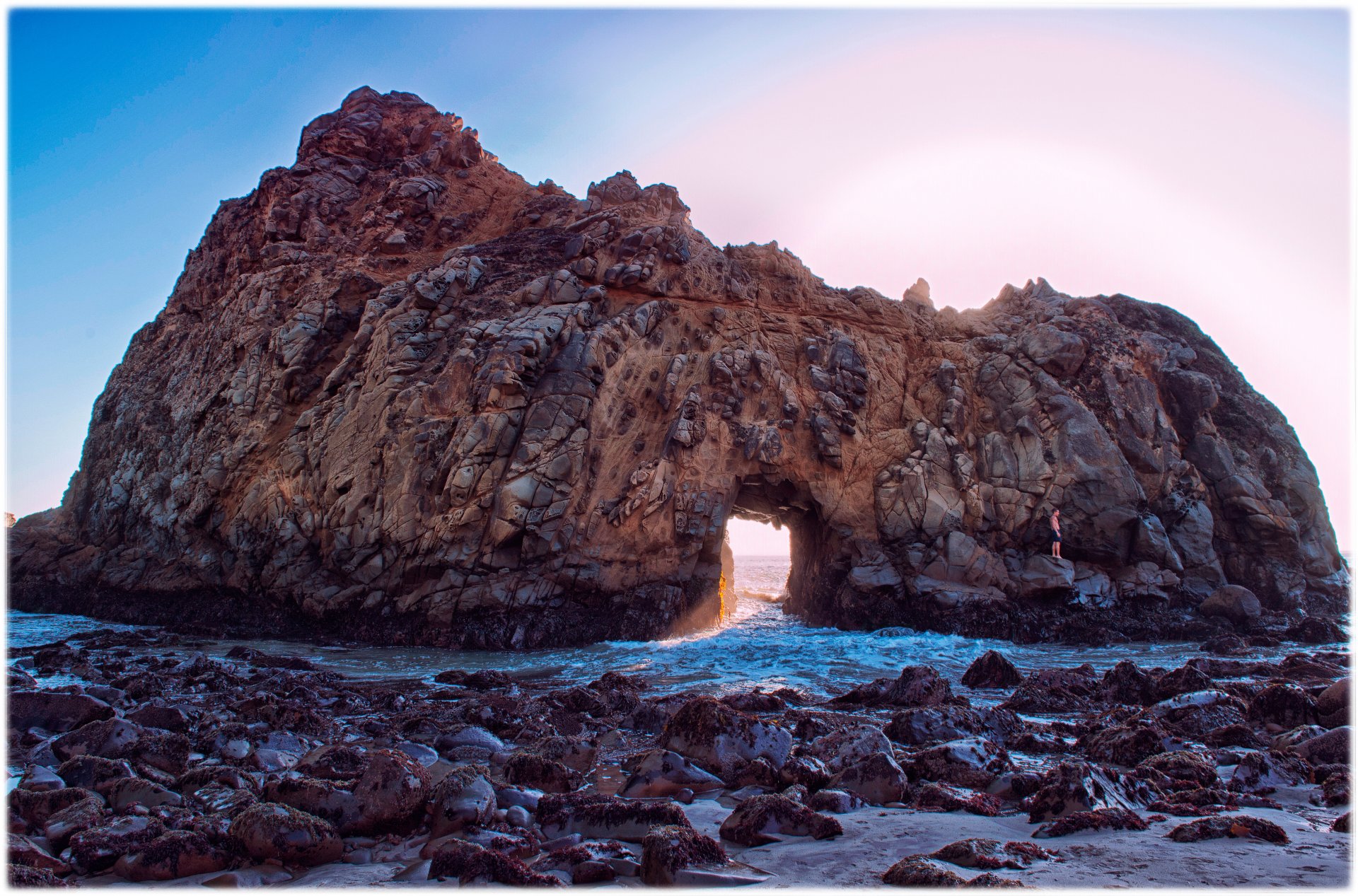 fioletowa plaża pfeiffer beach kalifornia usa skała skały spessartin minerał morze fale piana niebo słońce promienie