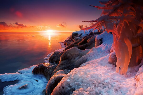 Winter evening sun in the ice of the lake