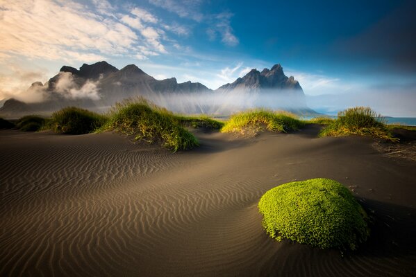 Montañas islandesas, arena y mar