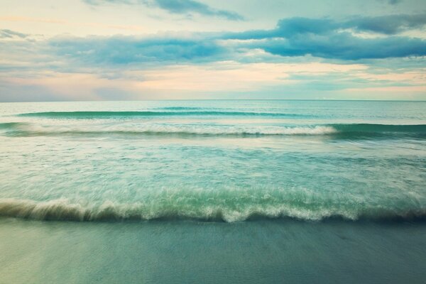 Vagues de la mer turquoise fusionnant avec le ciel