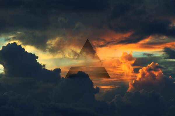Triángulo en las nubes contra el cielo iluminado por el sol