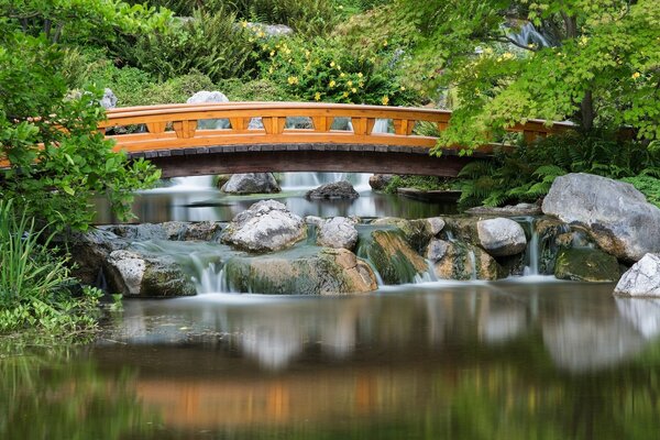 Puente en el Jardín pequeñas cascadas se vierten de las piedras