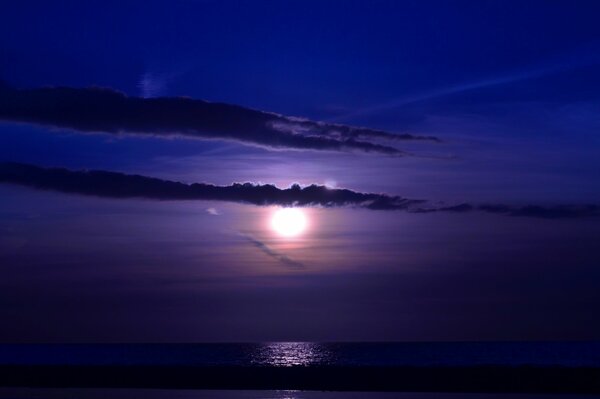 Sonnenuntergang in den Wolken am Meer in der Nacht