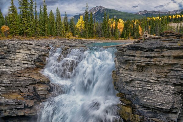 A powerful waterfall breaks down from the cliff