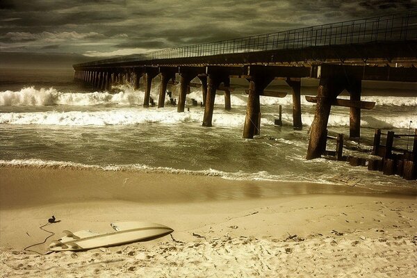 Puente roto durante una tormenta en una playa de arena