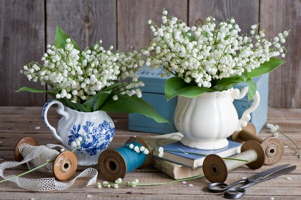 Bouquets of lilies of the valley in porcelain vases