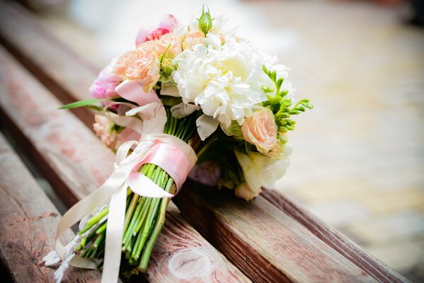 Bouquet de pivoines de mariage sur un banc