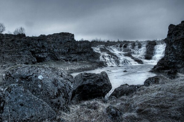 Paisaje oscuro. Cascada en las rocas