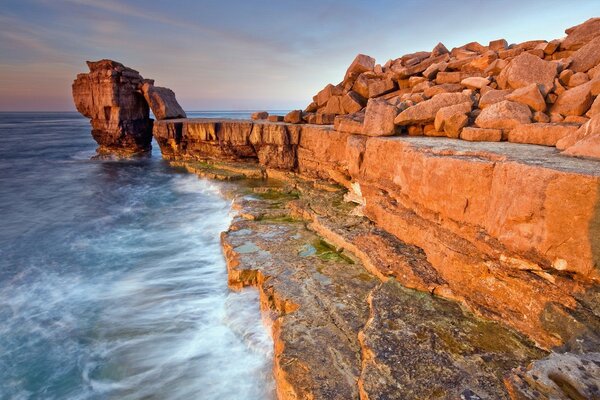 Sea waves wash the coastal rocks