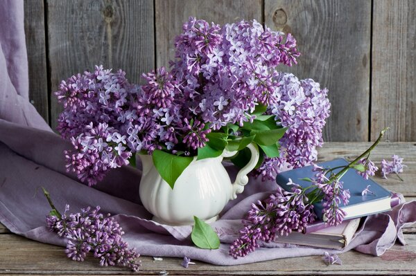 Still life with a bouquet of lilacs and a book
