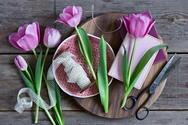 Tulpen, Bänder und Scheren liegen auf dem Tisch