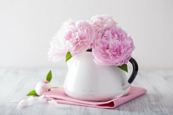 Peonie delicate in un vaso sul tavolo