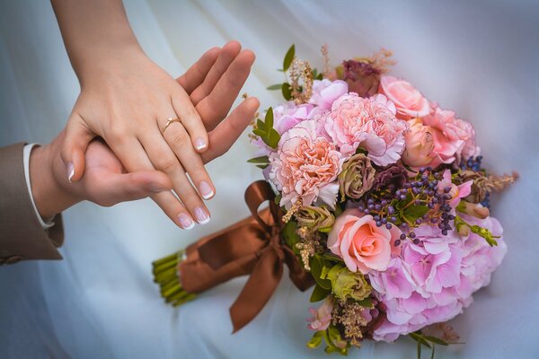 Mani di sposi e bouquet da sposa