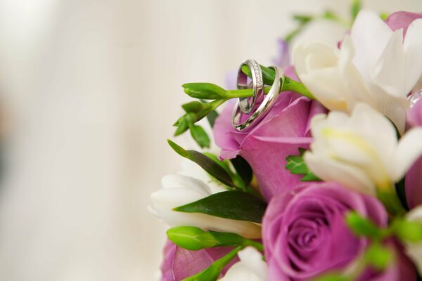 Verlobungsringe auf einem Blumenstrauß mit bunten Blumen