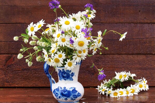 Still life with daisies in a jug and a wreath