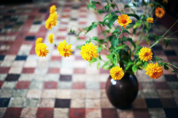 Bouquet of yellow chrysanthemums on long stems in a vase